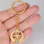 Llavero Ankh dorado con ala y piedra turquesa